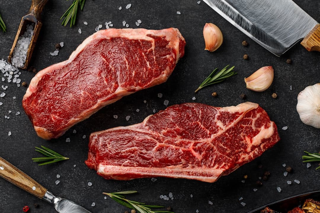Hand-cut raw steaks showing heavy marbling