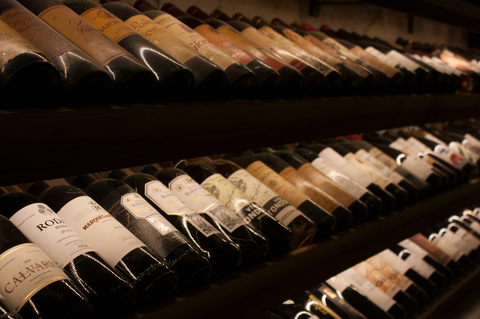 Wine bottles resting in the cellar rack
